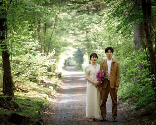 軽井沢のウェディングフォトで林の中で撮影するカップル