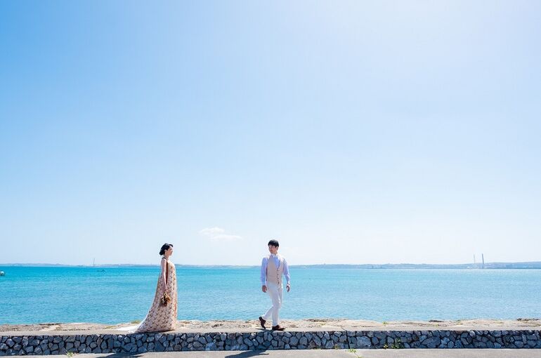 沖縄本島の海沿いでウェディングフォトをするカップル