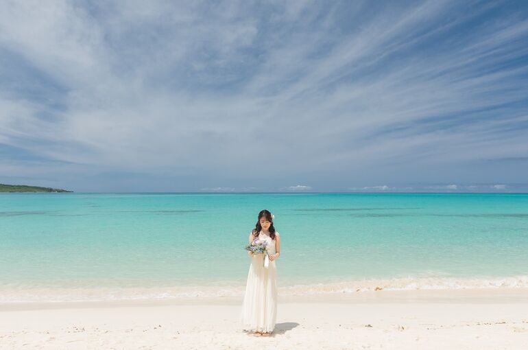 広いビーチの前で笑顔な新婦様