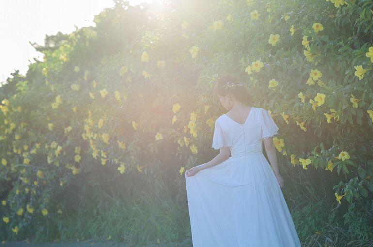 石垣島ウェディングフォトで花咲く木々の前で写真を撮る新婦